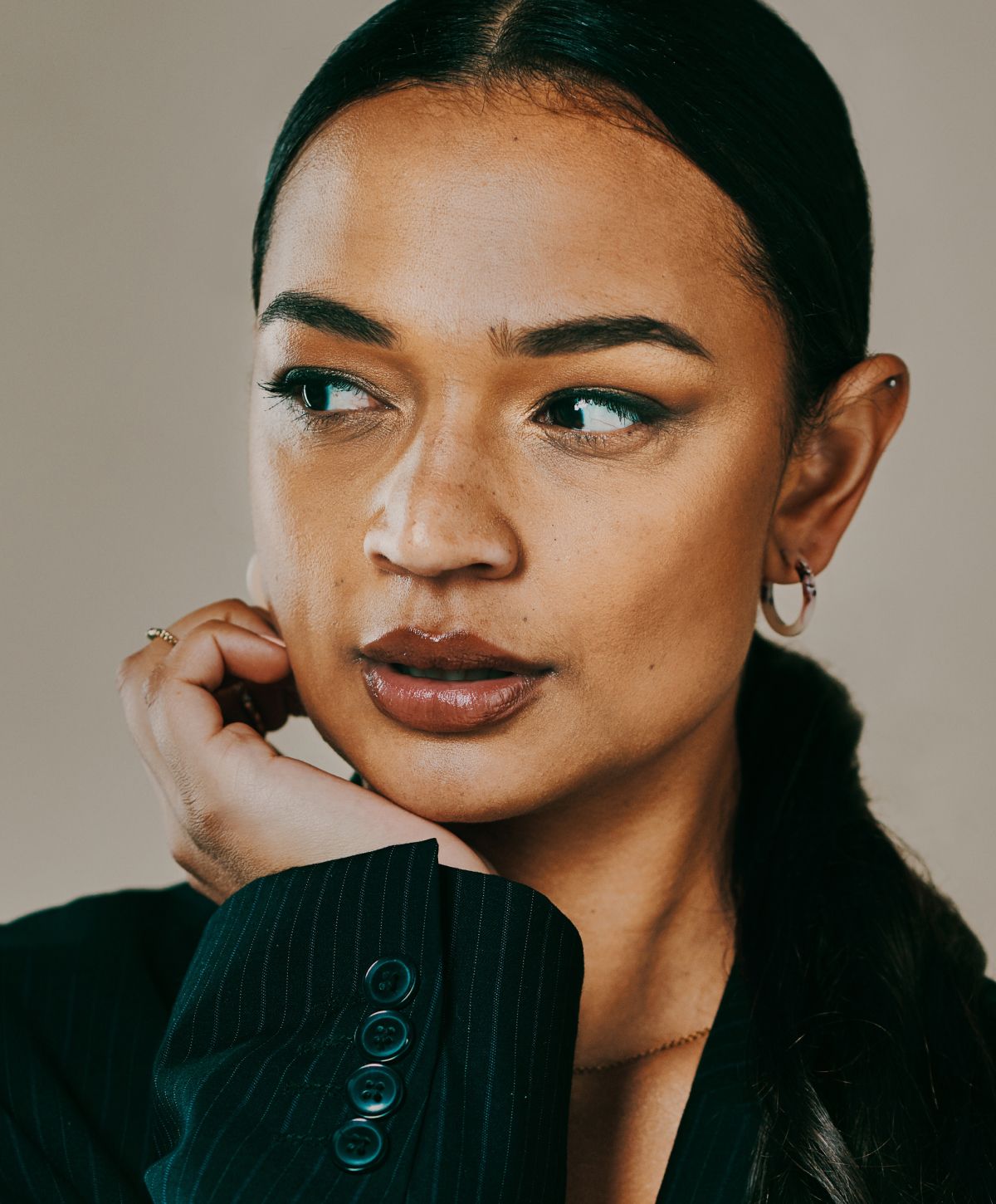 Woman in business attire with thoughtful expression.