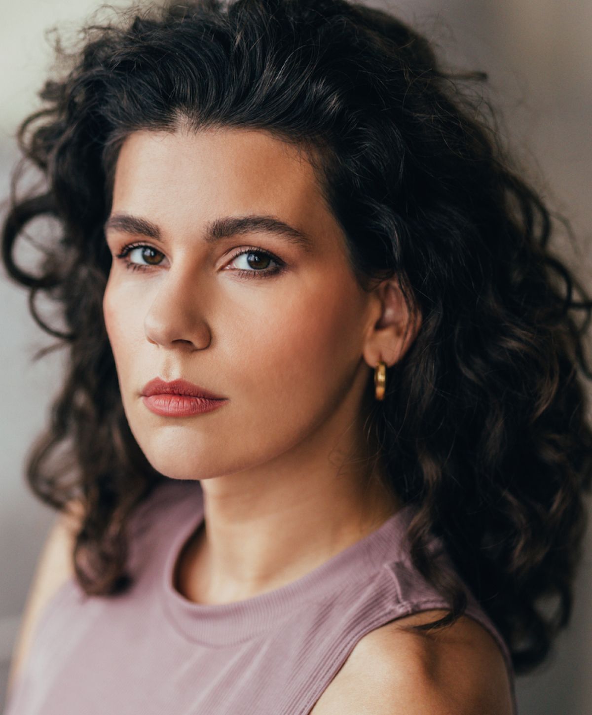 Woman with curly hair and natural makeup.