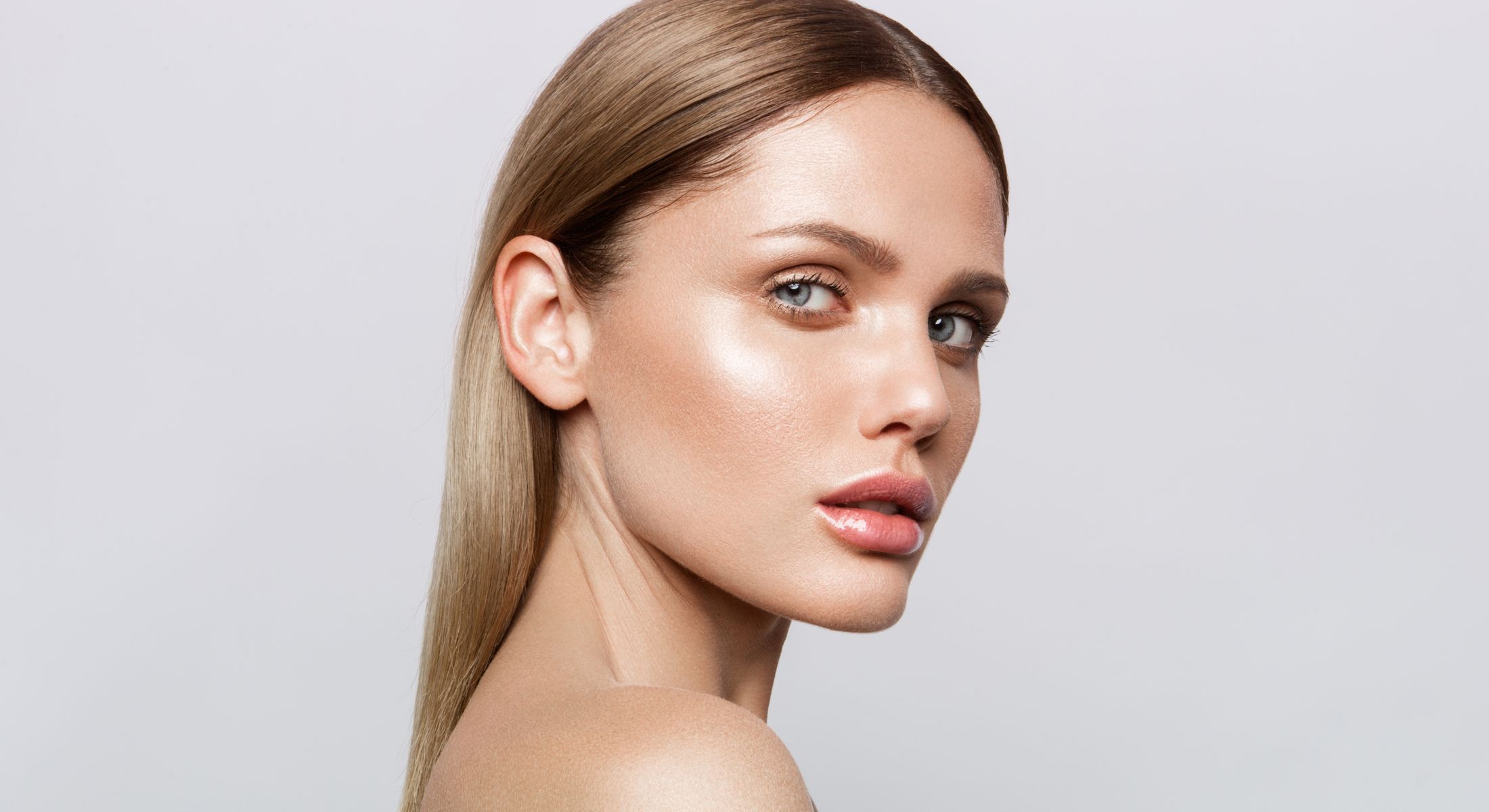 Woman with sleek hair and glowing skin.